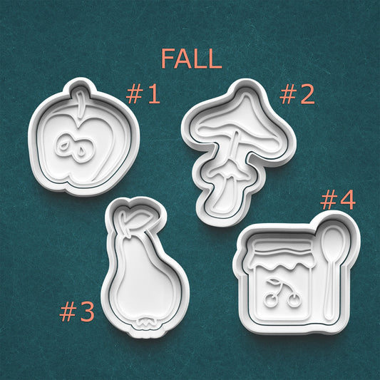 Set of four cookie cutters with fall-themed designs on a teal background