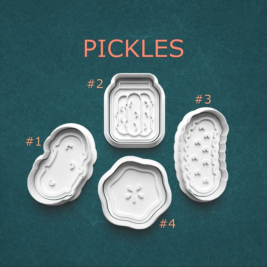 Four pickle-shaped cookie cutters on a teal background with 'PICKLES' text above.
