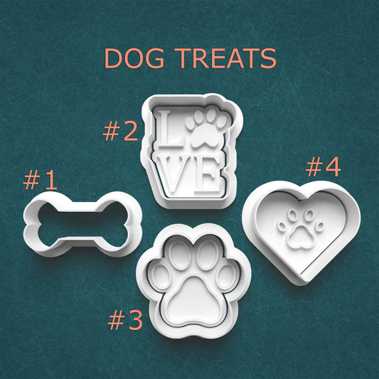 Dog treat molds with different shapes on a teal background