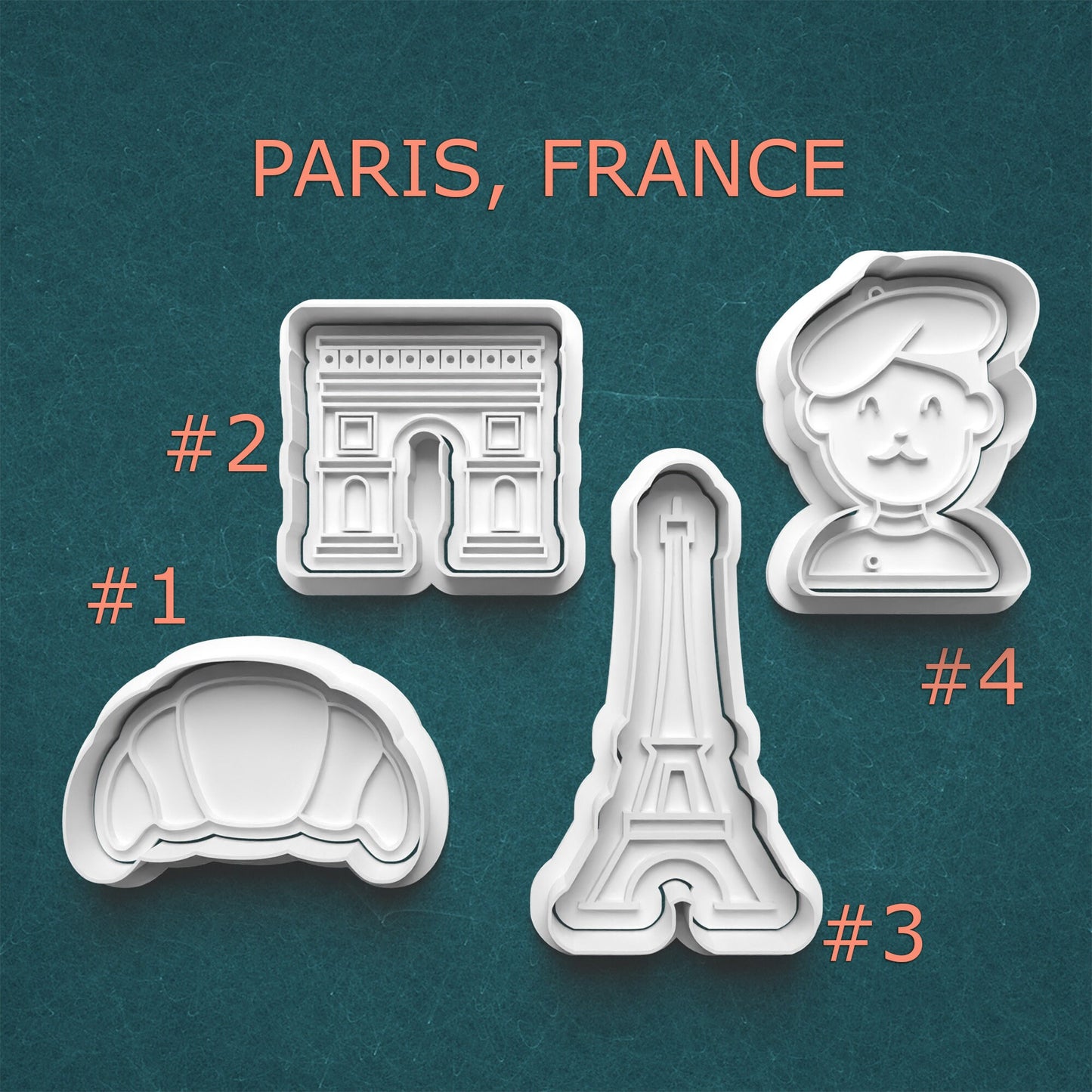 Set of cookie cutters shaped like famous Paris landmarks on a teal background.