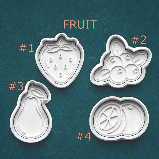 Four fruit-shaped cookie cutters on a teal background with 'Fruit' text above them.