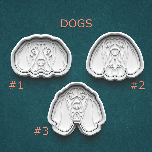 Three dog-shaped cookie cutters on a teal background with 'DOGS' text above them.