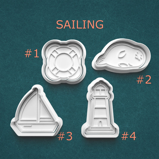 Set of four cookie cutters with sailing-themed designs on a teal background.