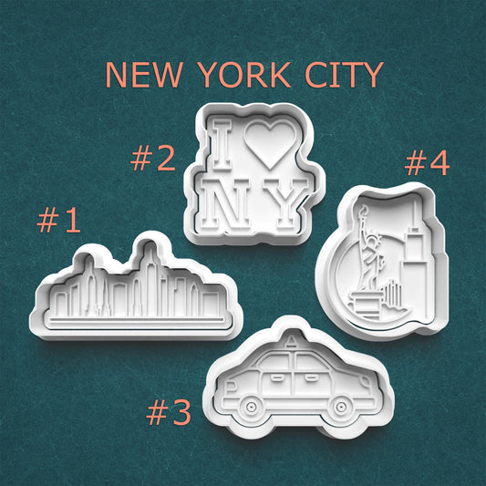 Four cookie cutters with New York City-themed designs on a teal background