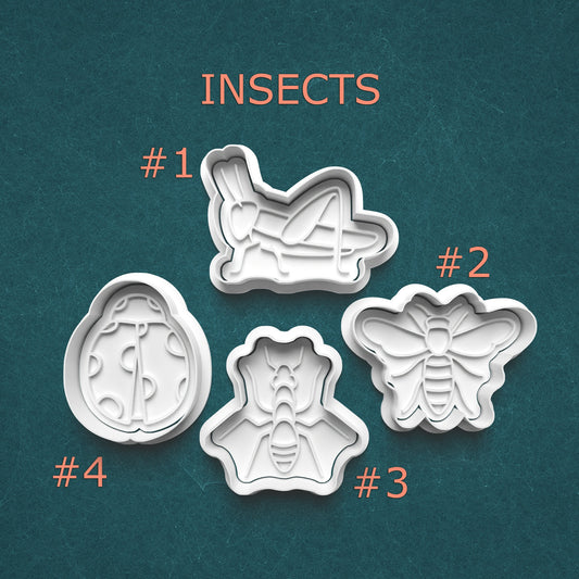 Set of four insect-shaped cookie cutters on a teal background