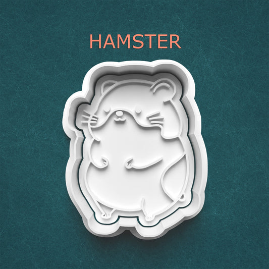 White hamster-shaped cookie cutter on a teal background with 'HAMSTER' text above.