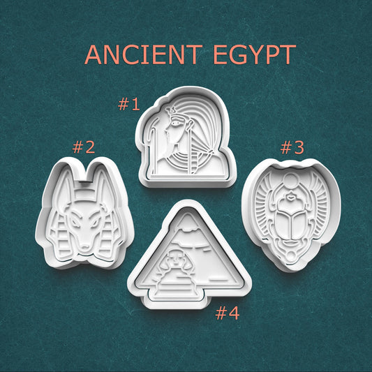 Set of four cookie cutters with ancient Egyptian designs on a teal background.