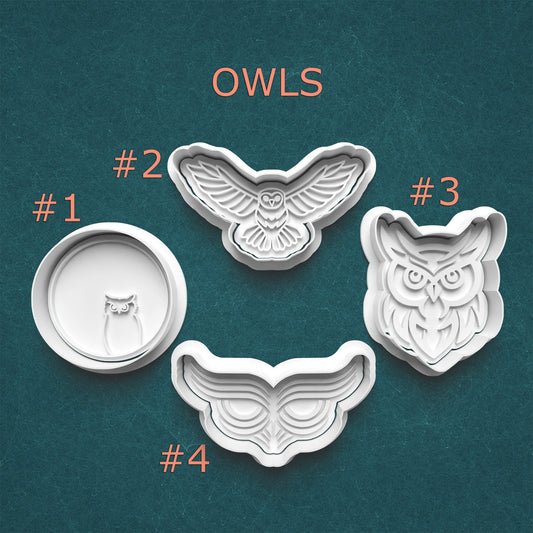 Set of four owl-shaped cookie cutters on a teal background