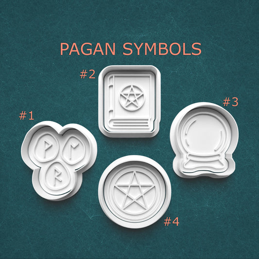 Set of four white cookie cutters with pagan symbols on a teal background