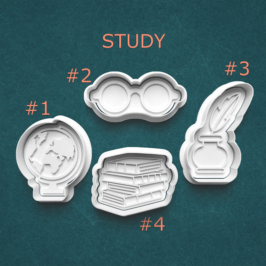 Set of four cookie cutters with study-themed designs on a teal background