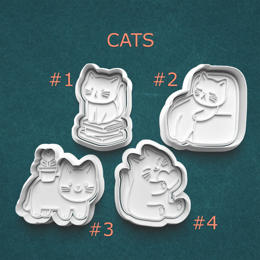 Four cat-shaped cookie cutters on a teal background