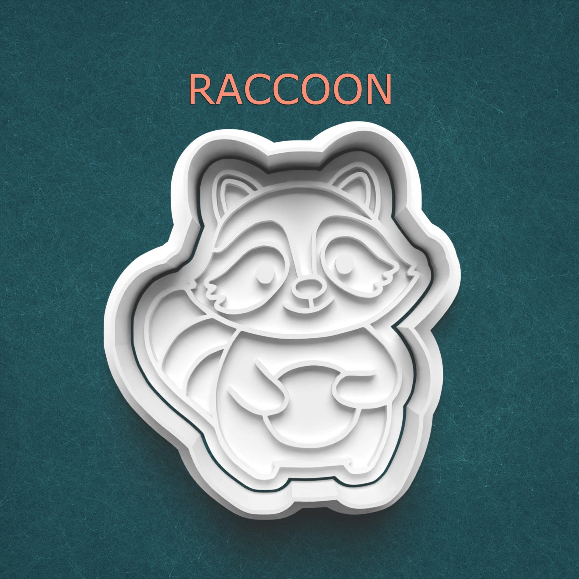 Raccoon-shaped cookie cutter on a teal background with 'RACCOON' text above.
