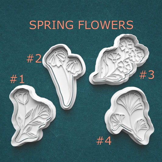 Set of four spring flower-shaped cookie cutters on a teal background