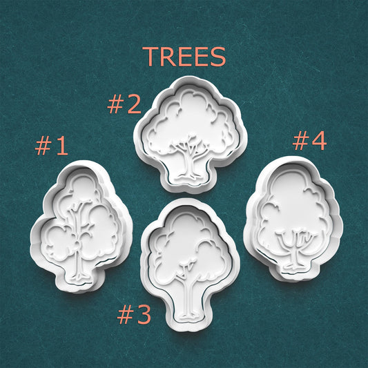Four tree-shaped cookie cutters on a teal background