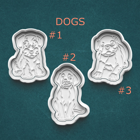Three dog-shaped cookie cutters on a teal background