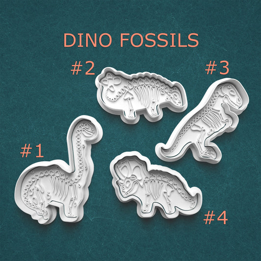 Four dinosaur fossil molds on a teal background