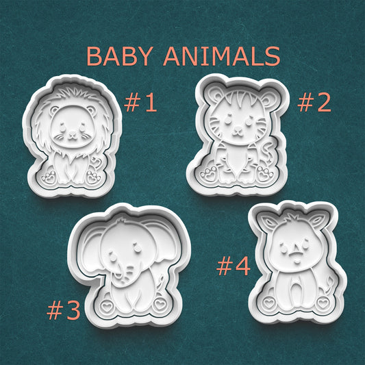 Four baby animal-shaped cookie cutters on a teal background