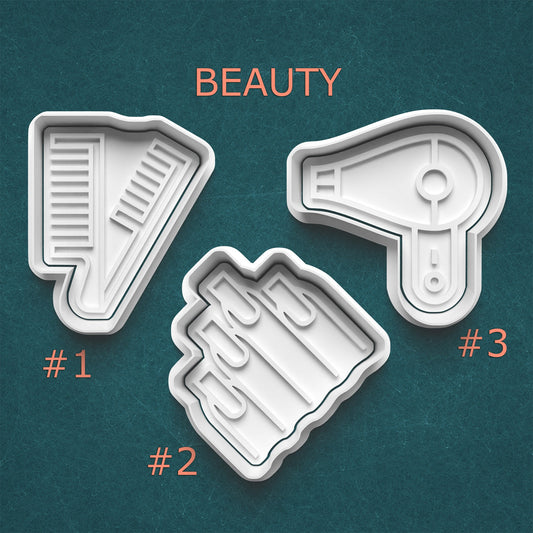 Three beauty product-shaped cookie cutters on a teal background with 'BEAUTY' text above them.