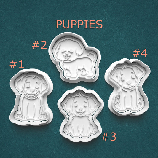 Four cookie cutters shaped like puppies on a teal background