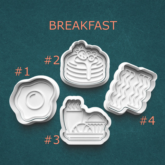 Set of four cookie cutters shaped like breakfast items on a teal background with 'BREAKFAST' text.