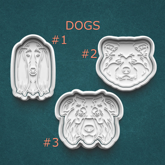 Three dog-shaped cookie cutters on a teal background