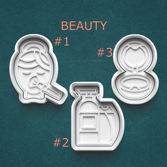 Three beauty product cookie cutters on a teal background