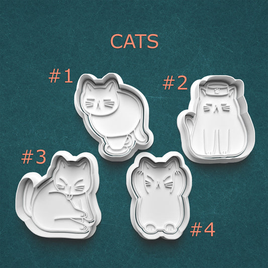 Four cat-shaped cookie cutters on a teal background