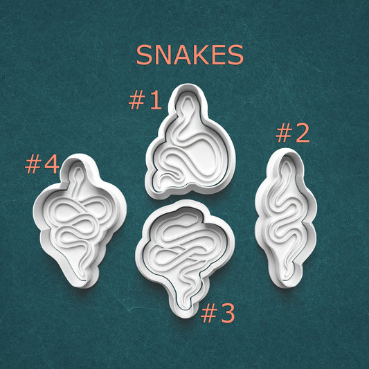 Four snake-shaped cookie cutters on a textured teal background